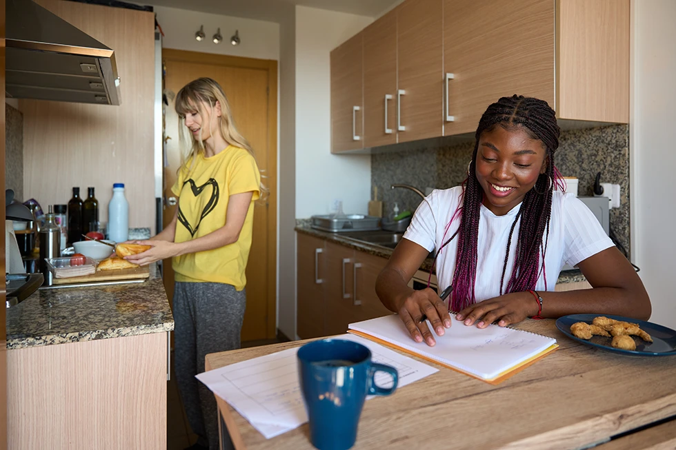 Students sharing apartment and studying while having breakfast
