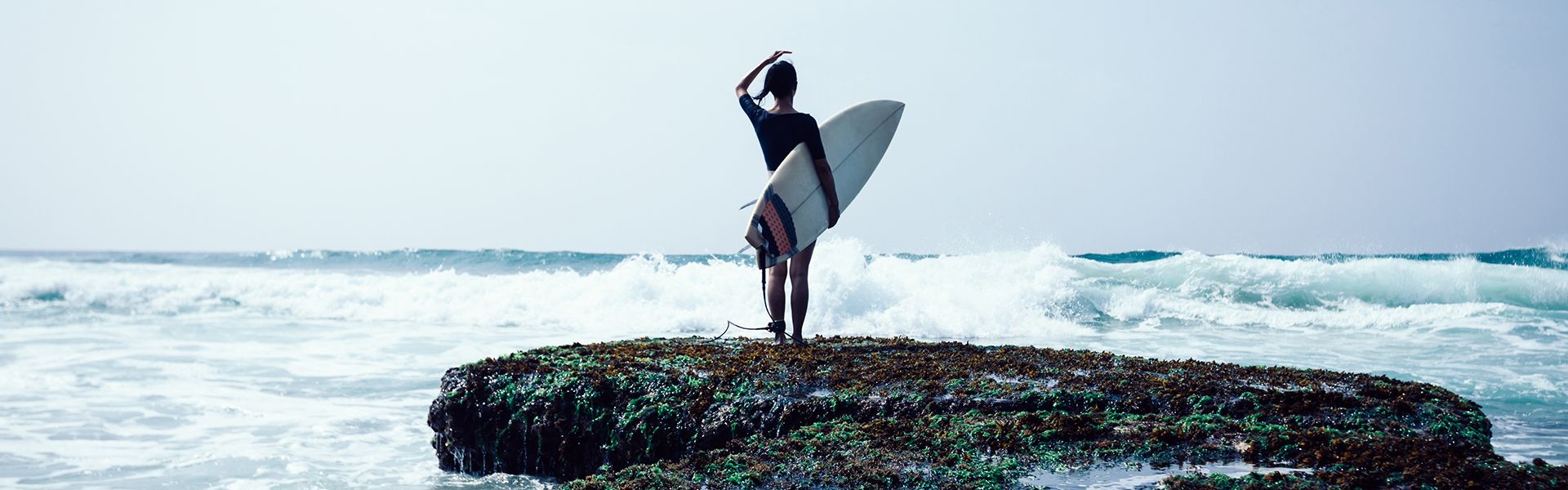 Girl at the beach with a surf board